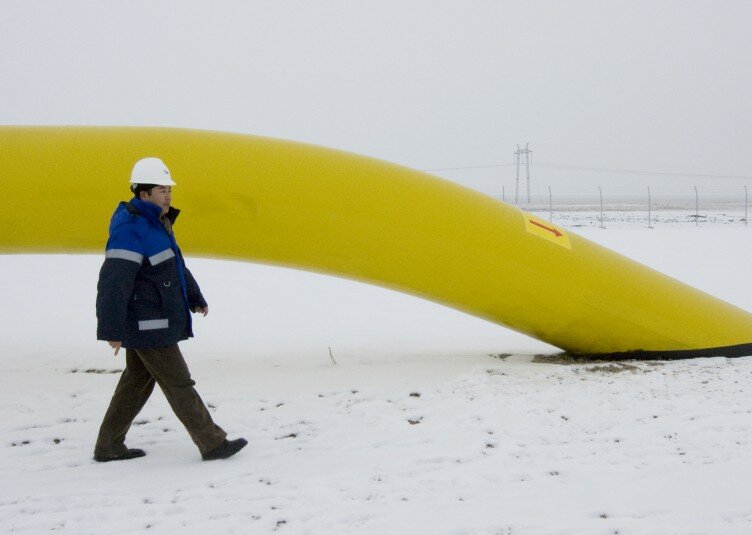 A Chinese worker of Asia Gas Pipeline (AGP) walks along the pipe of the Central Asia - China gas pipeline at Otar gas station outside Almaty